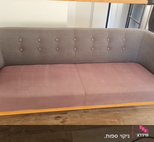 ספה אפורה ורודה בחדר מגורים עם רצפת עץ
